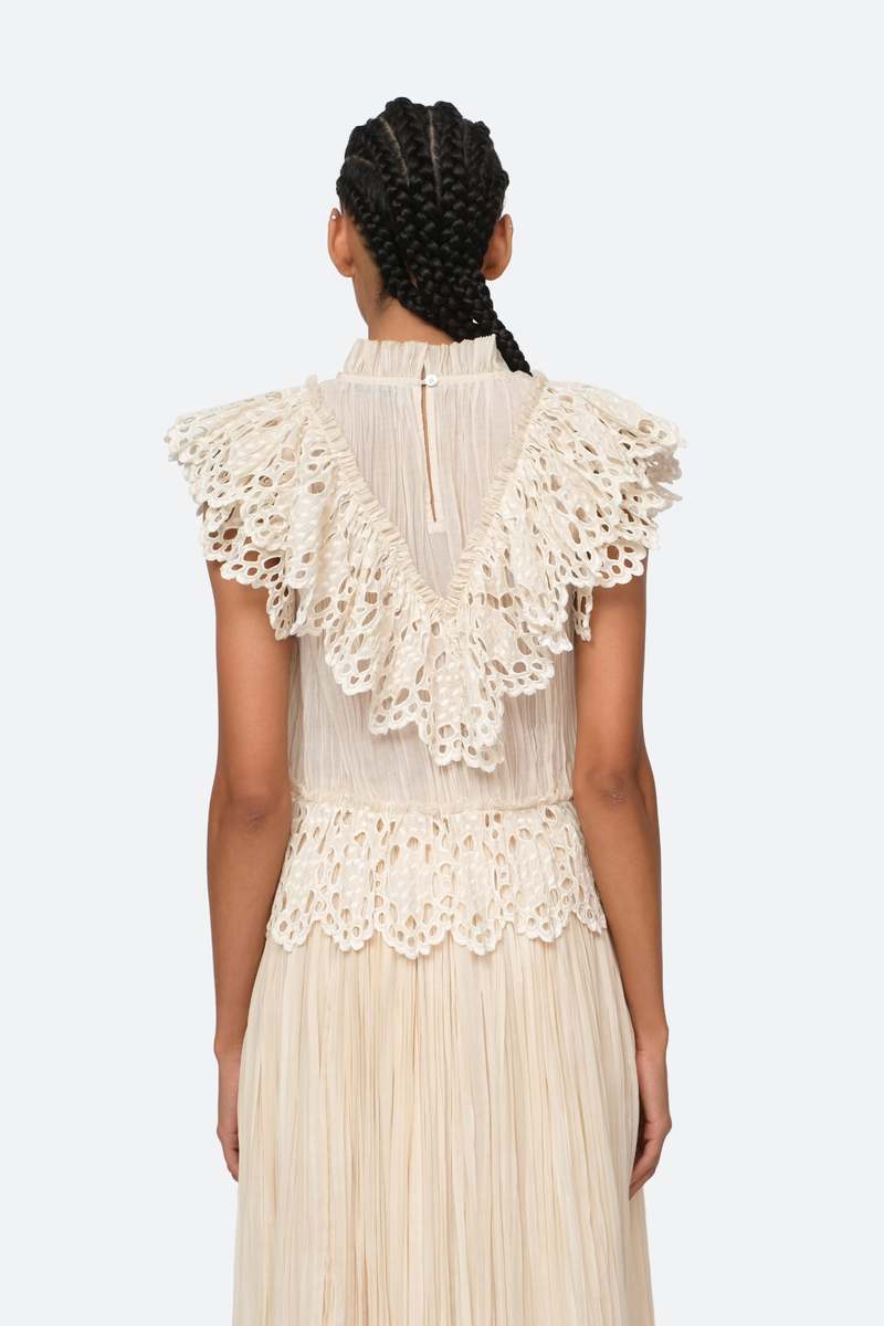 Indulge in luxury with the Cream Elise Eyelet Top by SEA. Featuring flutter sleeves and oversized eyelet detailing, this pleated top exudes elegance and sophistication. Perfect for any occasion, it effortlessly elevates your style. Add it to your wardrobe for a touch of exclusivity.