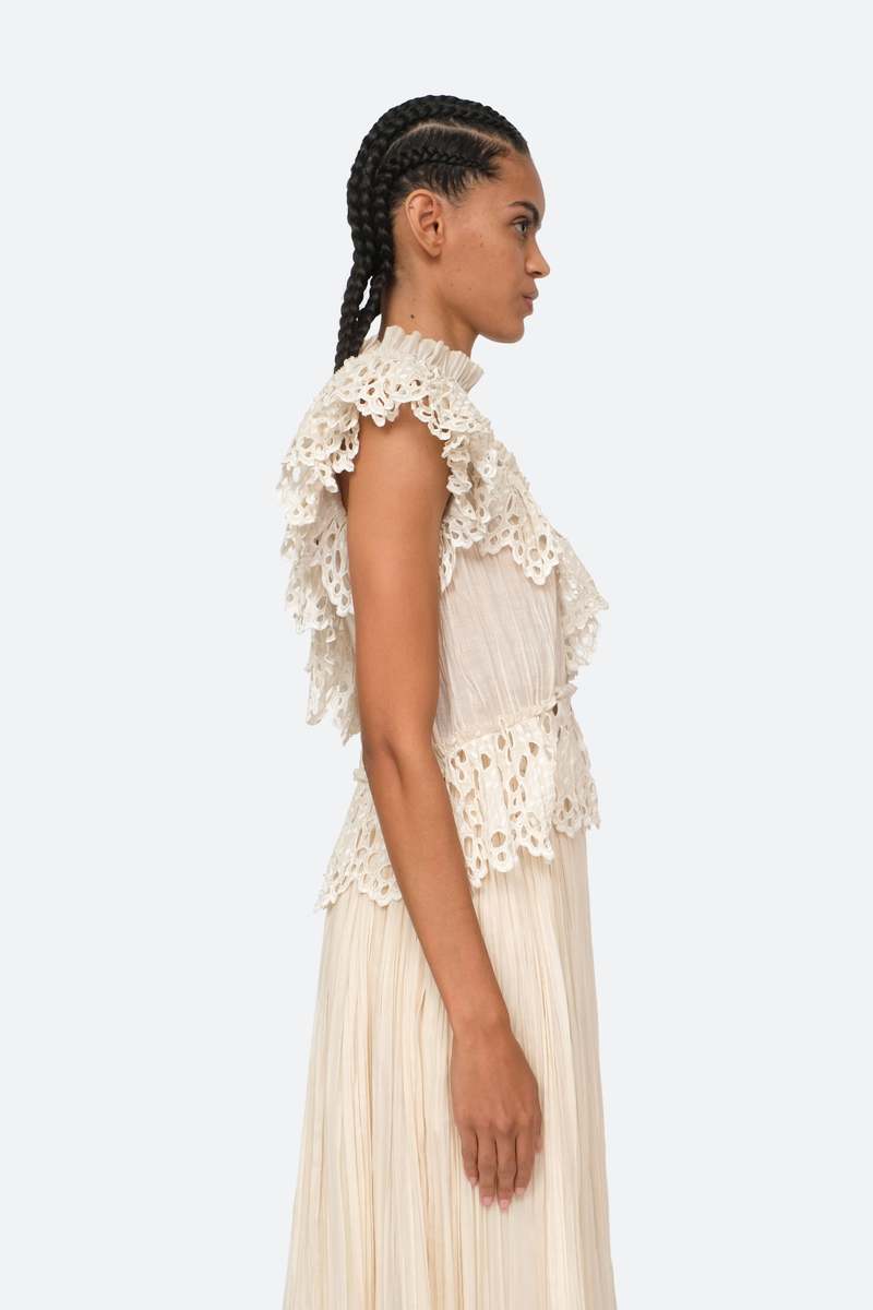 Indulge in luxury with the Cream Elise Eyelet Top by SEA. Featuring flutter sleeves and oversized eyelet detailing, this pleated top exudes elegance and sophistication. Perfect for any occasion, it effortlessly elevates your style. Add it to your wardrobe for a touch of exclusivity.