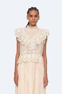 Indulge in luxury with the Cream Elise Eyelet Top by SEA. Featuring flutter sleeves and oversized eyelet detailing, this pleated top exudes elegance and sophistication. Perfect for any occasion, it effortlessly elevates your style. Add it to your wardrobe for a touch of exclusivity.
