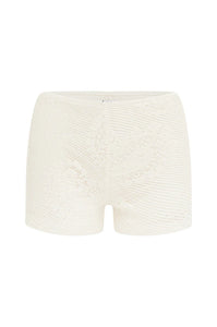 Elevate your wardrobe with the Dom Set by With Jean, expertly combining refined craftsmanship and elegant design. The Dom Top is a long-sleeve cardigan featuring a button-up front, a polished neckline collar, and delicate scalloped trim, enhanced by custom hand-drawn crochet lace for a sophisticated finish. Complementing the top, the Dom Shorts offer comfort with a fully lined interior and an elasticated waistband, adorned entirely with the same intricate crochet lace. 