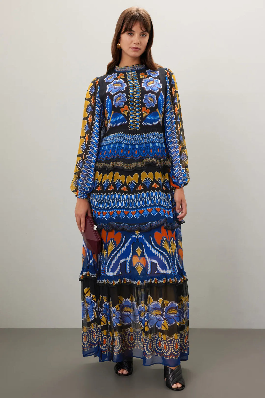 Elevate your autumn wardrobe with the Anika Maxi Dress by FARM Rio. Crafted from lightweight chiffon featuring a black geometric print, this A-line dress combines vibrant contrasting patterns with a delicate ruffle trim for a refined look. The long sleeves and mock neck provide subtle elegance, while the back zipper ensures a tailored fit. At 56 inches in length, its flowing silhouette effortlessly captures summer’s lively spirit well into the fall season. 