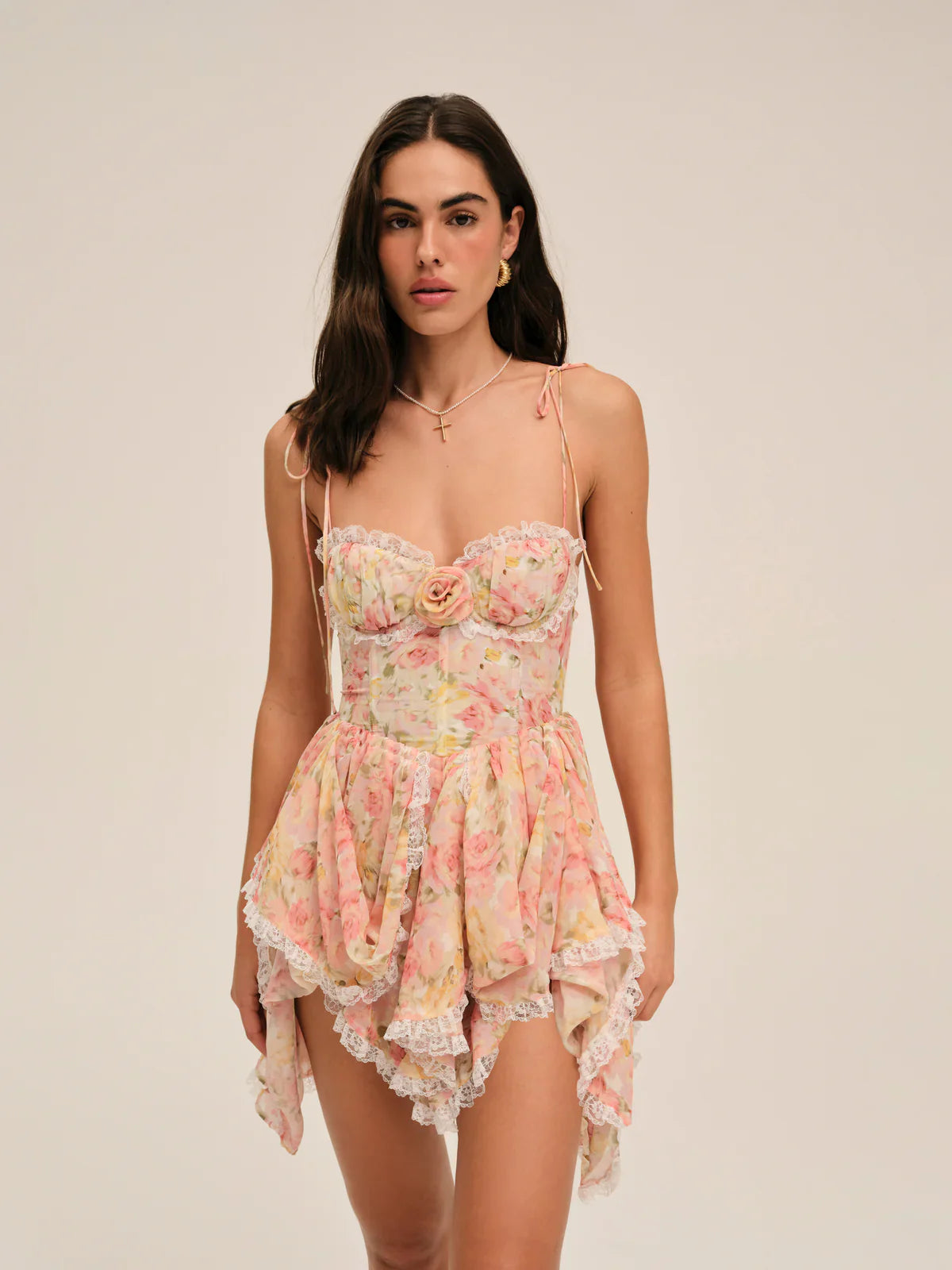 Elevate your summer wardrobe with the Elea Mini Dress, a delicate blend of romance and sophistication. This peach floral mini dress features structured underwire cups and a boned bodice for refined support and shape. Its multi-layered asymmetrical skirt gathers gracefully, ending with lace ruffles that add a subtle touch of elegance. Perfect for warm days and special occasions, the Elea Mini Dress offers a flattering silhouette that embodies effortless femininity.