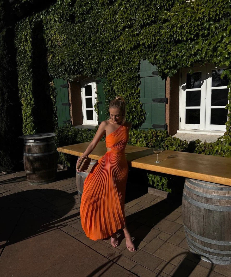 The Delfina Dress by ALC features an elegant one-shoulder design with a subtle side cut-out that adds a modern touch. Crafted from flowy pleated satin, its asymmetrical hem enhances movement and grace, making it perfect for sophisticated occasions.