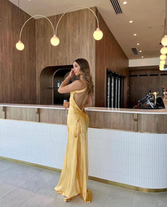 Elevate your presence and ignite your senses with the Monique Dress by Arcina Ori. This floor-length, bias-cut gown boasts a luxurious rich yellow hue that accentuates your curves. With an asymmetrical one-shoulder design, striking open back, and crossover detailing, Monique is crafted to embrace the feminine form.