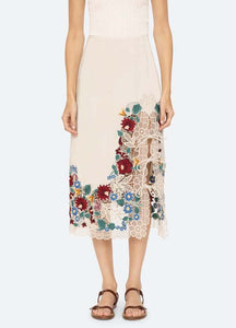The Katharine Skirt showcases a sophisticated asymmetrical front slit complemented by delicate self ties, enhancing its elegant silhouette. Crafted with intricate floral lace and detailed embroidery, this skirt offers a refined texture and visual appeal. Designed to coordinate seamlessly with the Katharine embroidered slip top, it provides a polished, cohesive look ideal for elevated occasions.
