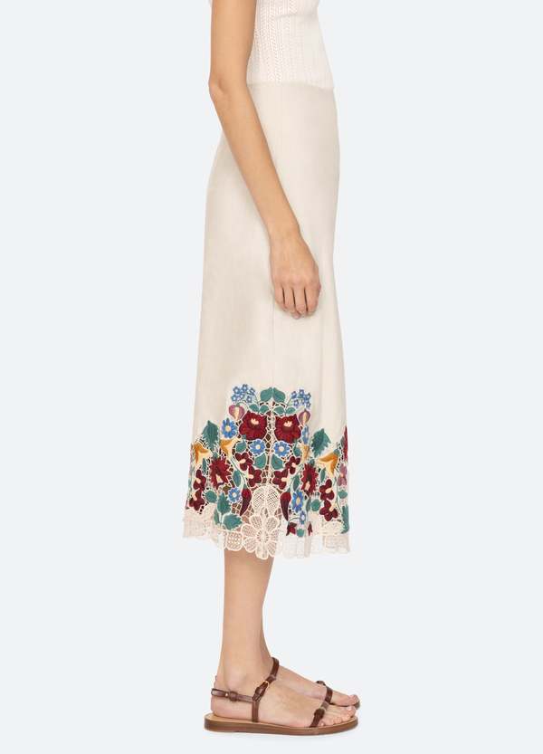 The Katharine Skirt showcases a sophisticated asymmetrical front slit complemented by delicate self ties, enhancing its elegant silhouette. Crafted with intricate floral lace and detailed embroidery, this skirt offers a refined texture and visual appeal. Designed to coordinate seamlessly with the Katharine embroidered slip top, it provides a polished, cohesive look ideal for elevated occasions.