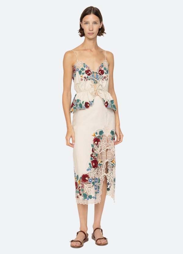 The Katharine Skirt showcases a sophisticated asymmetrical front slit complemented by delicate self ties, enhancing its elegant silhouette. Crafted with intricate floral lace and detailed embroidery, this skirt offers a refined texture and visual appeal. Designed to coordinate seamlessly with the Katharine embroidered slip top, it provides a polished, cohesive look ideal for elevated occasions.