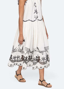 The Kingsley embroidered tank dress in cream by SEA NY showcases intricate embroidery throughout its design, offering a refined and elegant appeal. It features a high neckline that adds a sophisticated touch, complemented by a delicate back bow tie for adjustable fit and added charm. The scalloped hemline enhances the dress's feminine silhouette, making it an exceptional choice for those seeking a polished yet distinctive look.