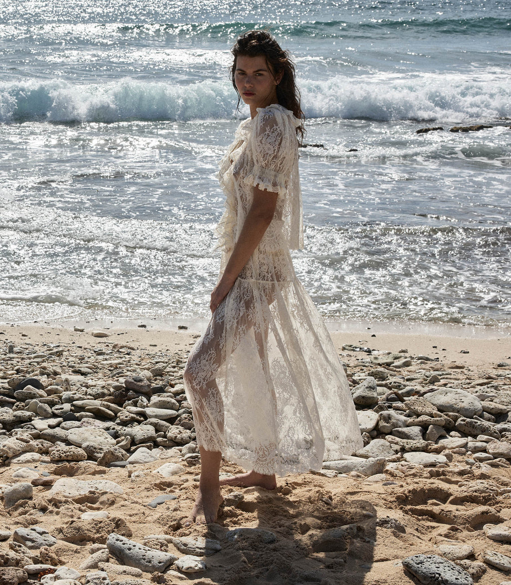 Crafted from delicate chantilly-inspired lace, the Sebastiane skirt by Doen embodies timeless elegance with its romantic silhouette. The high-waisted A-line cut flatters the figure while the scalloped hem adds refined detail, falling gracefully to mid-shin length. Unlined for a lightweight feel, this piece pairs beautifully with a slip for layering versatility. Perfect for those seeking sophisticated, vintage-inspired style with contemporary comfort.
