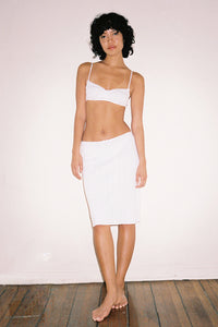 The Slip Skirt by Cou Cou Intimates offers a fresh take on a timeless silhouette, expertly designed for comfort and movement. Crafted to enhance your daily wardrobe, it features a delicate flounce hem and scalloped picot trim that add subtle charm. The petite baby bow at the center front adds a refined touch, while the pull-on style ensures effortless wear. Ideal for graceful twirls or casual days, this skirt balances elegance with ease.
