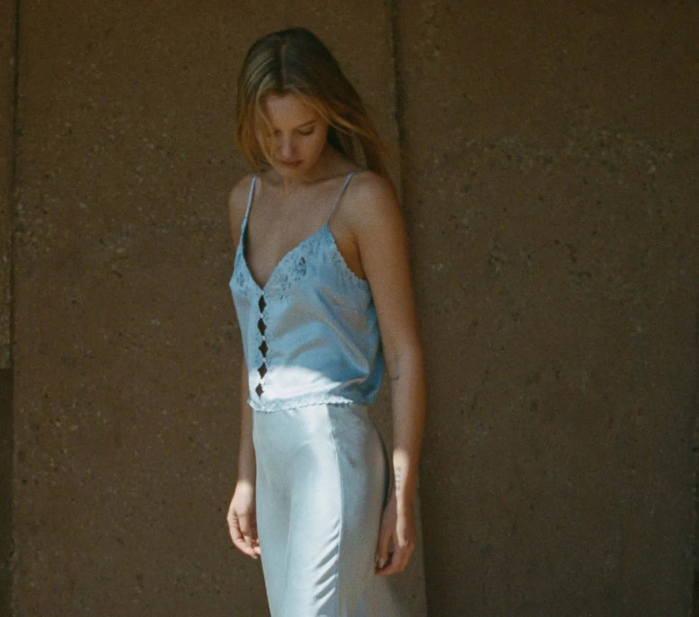 Crafted from sumptuous sandwashed satin, the Elise Top by DÔEN boasts ultra-skinny adjustable spaghetti straps and artful cutouts that sculpt a refined silhouette. Its plunging V-neckline features scalloped edges, enhanced by intricate floral eyelet embroidery and delicate hand-embroidered butterflies at the neckline, back, and hem. Elegant flower-shaped mother-of-pearl buttons complete the design, offering a sophisticated finish suitable for both everyday wear and distinguished events. 