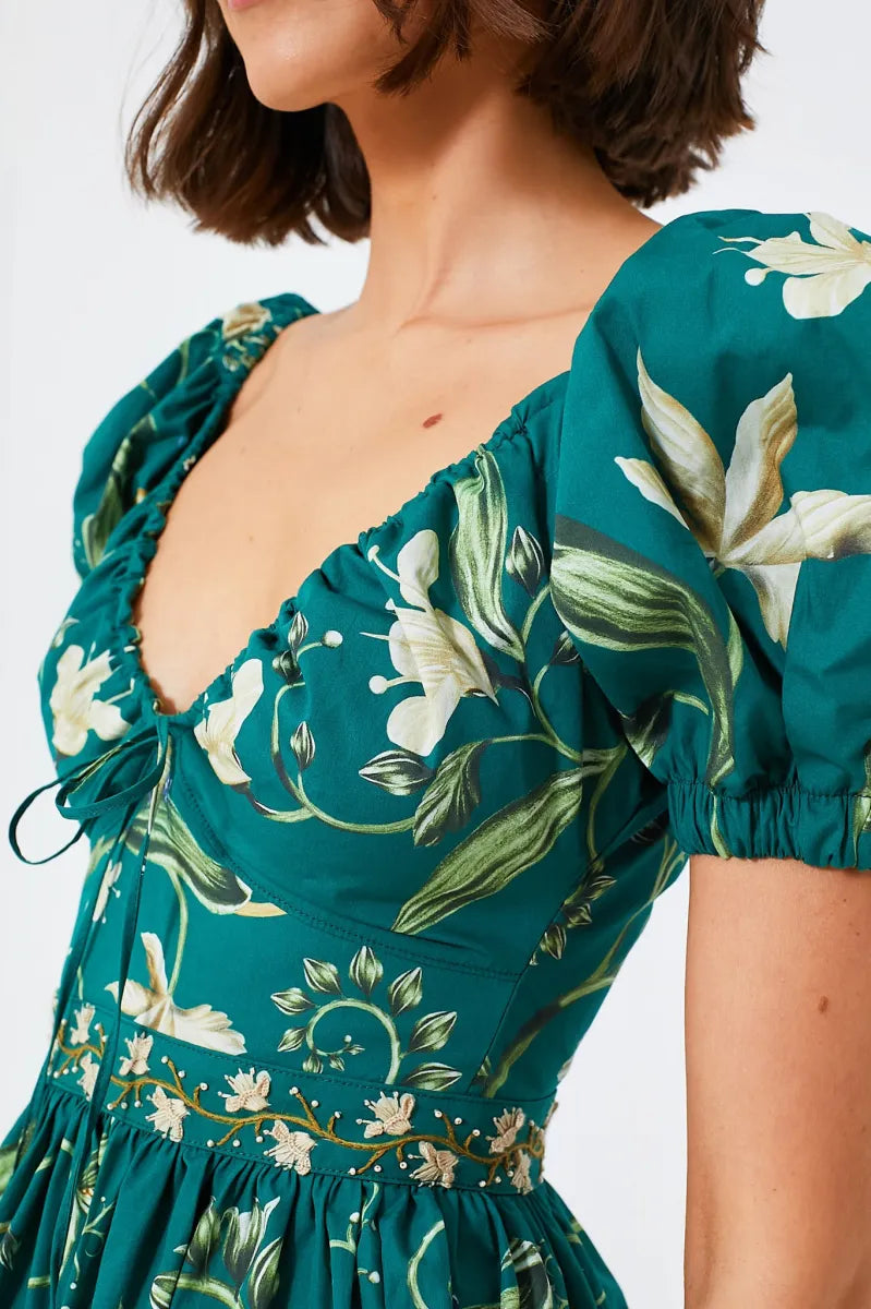 The Esmeralda Manzanilla Mini Dress combines effortless style with comfort, crafted from breathable 100% cotton poplin. Its adjustable deep-v neckline with a delicate drawstring ensures a custom fit, while the hand-embroidered waistline adds a refined artisanal touch. Featuring a concealed back zip for a seamless silhouette, this dress is perfect for warm days and tropical evenings. Elevate your look by pairing it with espadrilles or heels and statement jewelry for a polished, vibrant outfit.