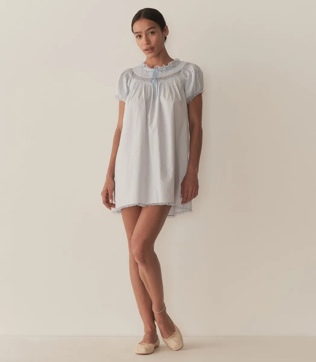 The Daphné Dress by Doen, crafted from crisp organic cotton poplin, offers a refined feminine silhouette with its flattering A-line cut and short puffed sleeves. Featuring delicate floral scallop lace, pintuck accents, and a grosgrain ribbon tie at the neckline, it balances elegance and detail. The scalloped lace trims on the cuffs and hem provide subtle sophistication, making this mini-length dress ideal for warm weather or casual occasions where comfort and style are paramount.