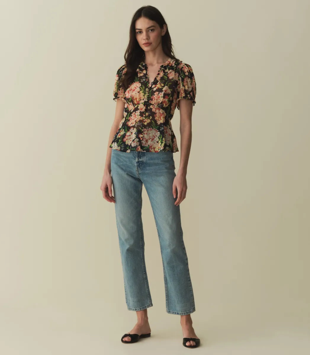 The Alona Top by Doen offers timeless sophistication with its light silk georgette fabric and 1930s-inspired design. Featuring short puffed sleeves and a Peter Pan collar adorned with delicate picot-edged ruffles, this blouse highlights a shirred bust that flows into a breezy, slightly cropped silhouette with a bias-cut hem. Self-covered buttons along the front enhance its refined charm. 