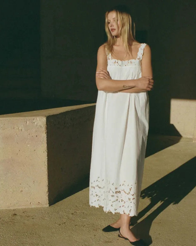 Crafted from organic cotton poplin, the Ellen Dress in Salt showcases expert detailing with a square neckline featuring hand-placed floral embroidery cutwork. Thick straps ensure comfort and support, while the ankle-length hem is enhanced by clustered pintucks and shirring, adding subtle texture. This breathable maxi dress combines refined elegance with effortless wearability, making it an excellent choice for warm-weather occasions that call for both style and comfort.
