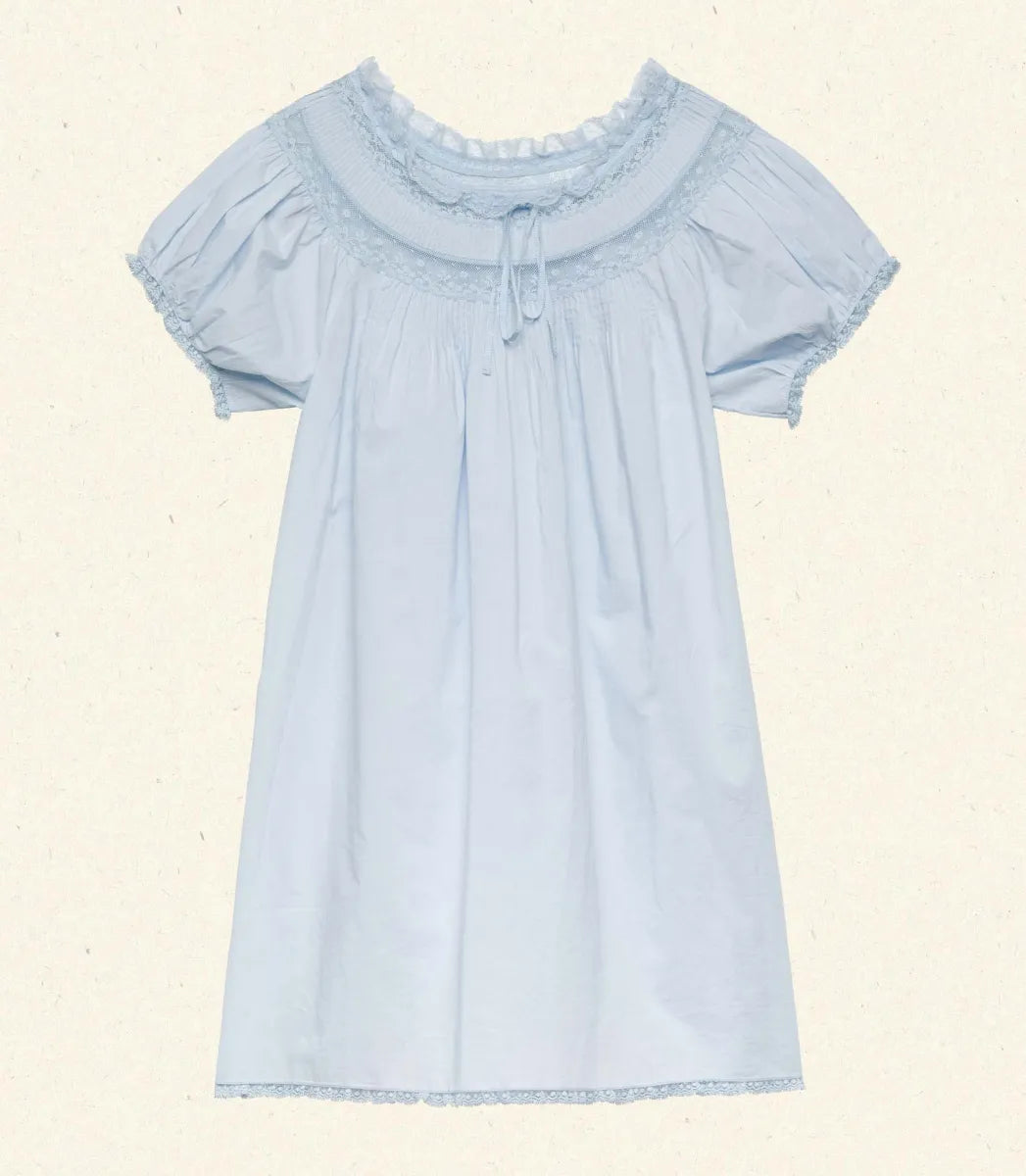 The Daphné Dress by Doen, crafted from crisp organic cotton poplin, offers a refined feminine silhouette with its flattering A-line cut and short puffed sleeves. Featuring delicate floral scallop lace, pintuck accents, and a grosgrain ribbon tie at the neckline, it balances elegance and detail. The scalloped lace trims on the cuffs and hem provide subtle sophistication, making this mini-length dress ideal for warm weather or casual occasions where comfort and style are paramount.