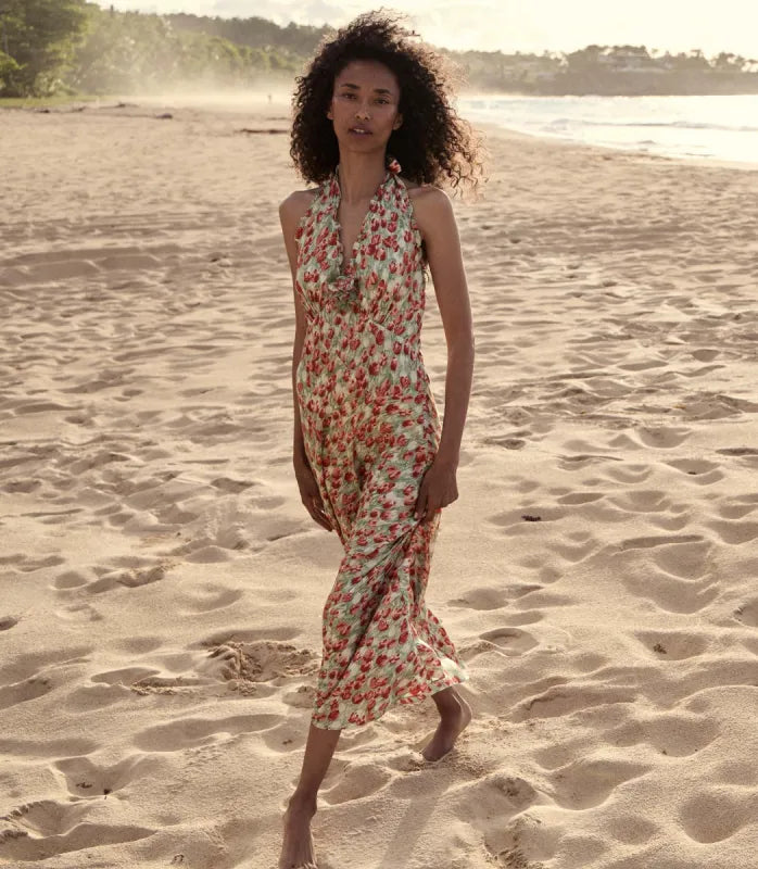 The Mazarin Dress in Tulip Fields by Doen exemplifies refined 1990s elegance with its buttery silk-viscose fabric and plunging halter neckline detailed with delicate ruffles. Featuring a fitted bodice and an invisible side zipper for a seamless fit, it also includes a removable silk georgette rosette brooch that adds versatile sophistication. 