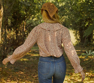 The Hardy Top combines classic sophistication with a touch of vintage flair, featuring full sleeves and a delicate ruffle detail along its mother of pearl button placket. Its pintucked, airy construction highlighted by the vibrant Songbird Paisley print channels 1970s elegance. Designed for versatility, this blouse seamlessly enhances both casual and polished ensembles, offering a refined yet comfortable option suitable for a variety of occasions.
