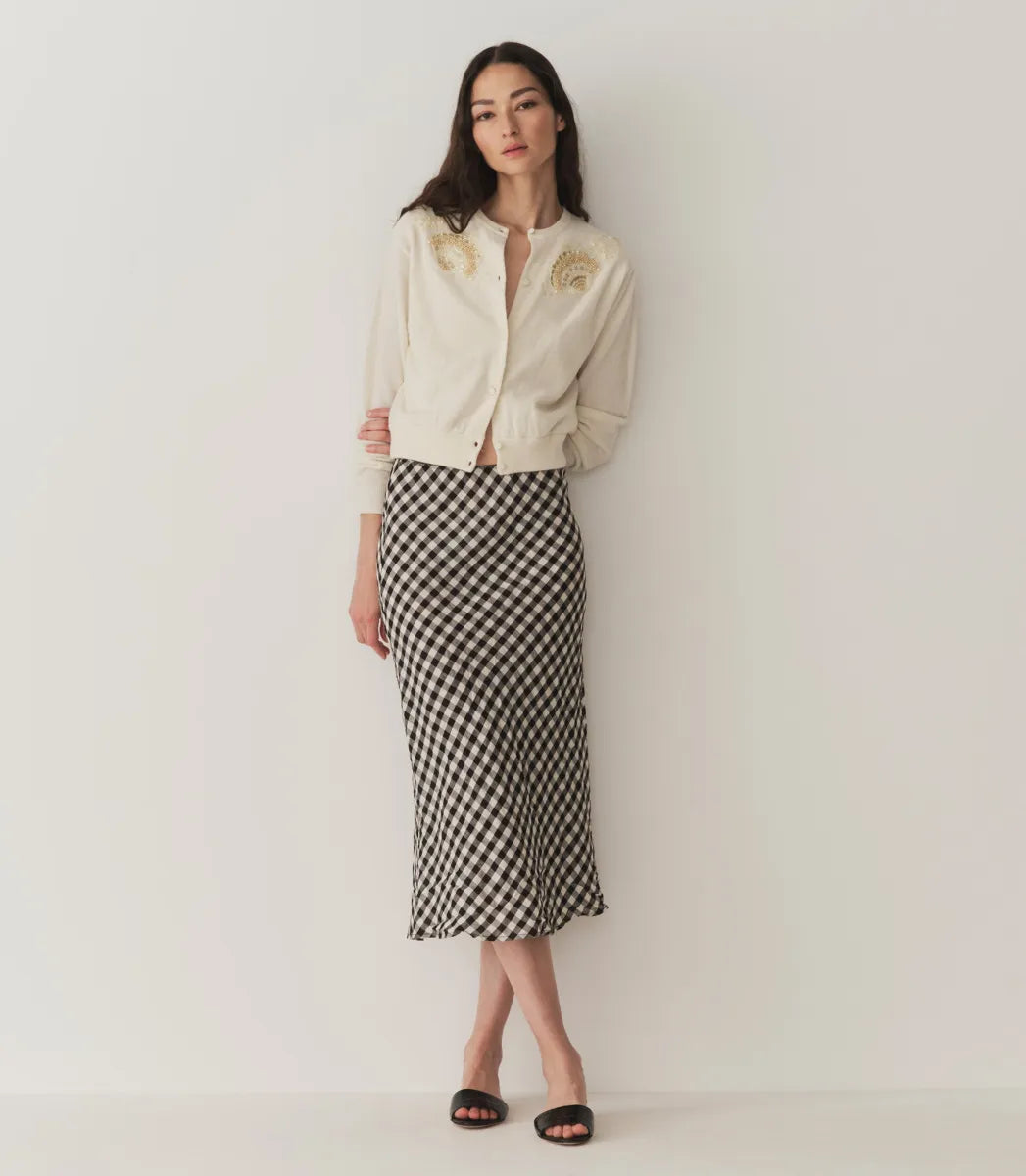 The Elowen Skirt in Marilyn Gingham by Doen offers a refined midi length enhanced by a timeless gingham pattern. Crafted from lightweight fabric, its flowy silhouette ensures comfort without sacrificing style. Versatile enough for casual or formal settings, this skirt pairs seamlessly with diverse tops and accessories, making it a sophisticated staple for any wardrobe seeking effortless elegance.