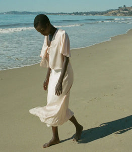 Indulge in timeless elegance with the Elowen Skirt from Doen. This luxurious silk satin skirt features delicate scallop elastic trims and a bias-cut midi design adorned with intricate contrast lace. Its high-waisted silhouette adds a touch of '90s nostalgia, perfect for pairing with the Chantal Top for an elevated matching set. From day to night, embrace sophistication with the Elowen Skirt.