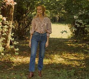 The Hardy Top combines classic sophistication with a touch of vintage flair, featuring full sleeves and a delicate ruffle detail along its mother of pearl button placket. Its pintucked, airy construction highlighted by the vibrant Songbird Paisley print channels 1970s elegance. Designed for versatility, this blouse seamlessly enhances both casual and polished ensembles, offering a refined yet comfortable option suitable for a variety of occasions.