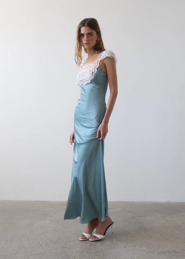 The Tish Dress is where vintage nightgown nostalgia collides with '90s glamour. Crafted in luxurious blush blue silk that drapes beautifully, this romantic piece features delicate white lace detailing, a flattering ruched bust, and charming cap sleeves. Perfect for date nights, garden gatherings, or lazy afternoons at home, it's the effortless elegance you'll reach for again and again. Slip into something that feels like a dream.