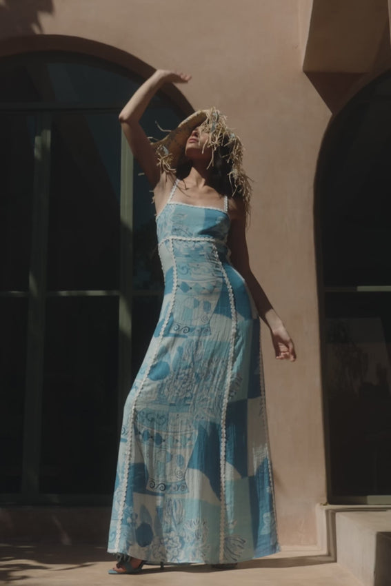 Introducing the Terazza Dress in the exclusive Vaso Blu print—a stunning piece inspired by traditional Mediterranean vases and florals. Crafted from a luxurious viscose nylon blend, this maxi dress features delicate ric rac detailing on the straps, panels, and trim edges. The flattering A-line silhouette is enhanced by a tie-back closure, creating an effortlessly elegant look. Perfect for those who appreciate timeless design with a contemporary twist.
